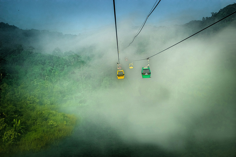 Tourists can use a cable car to reach the top of Cam Mountain if they are short on time. The 3.5-kilometer-long cable car journey allows visitors to admire floating clouds and a panorama of breathtaking mountains. Photo: Duong Viet Anh / Tuoi Tre