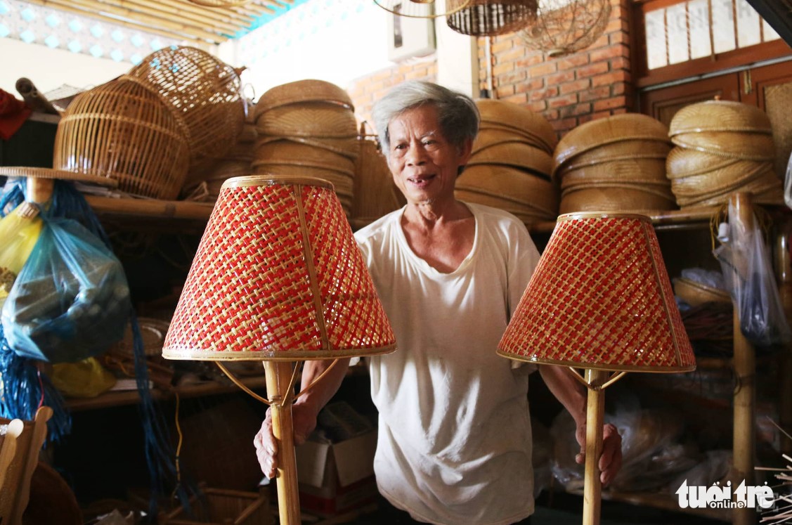 Artisan Thai Phi Hung holds two bamboo lamp containers, which are among the most sophisticated models. Photo: Tran Mai / Tuoi Tre