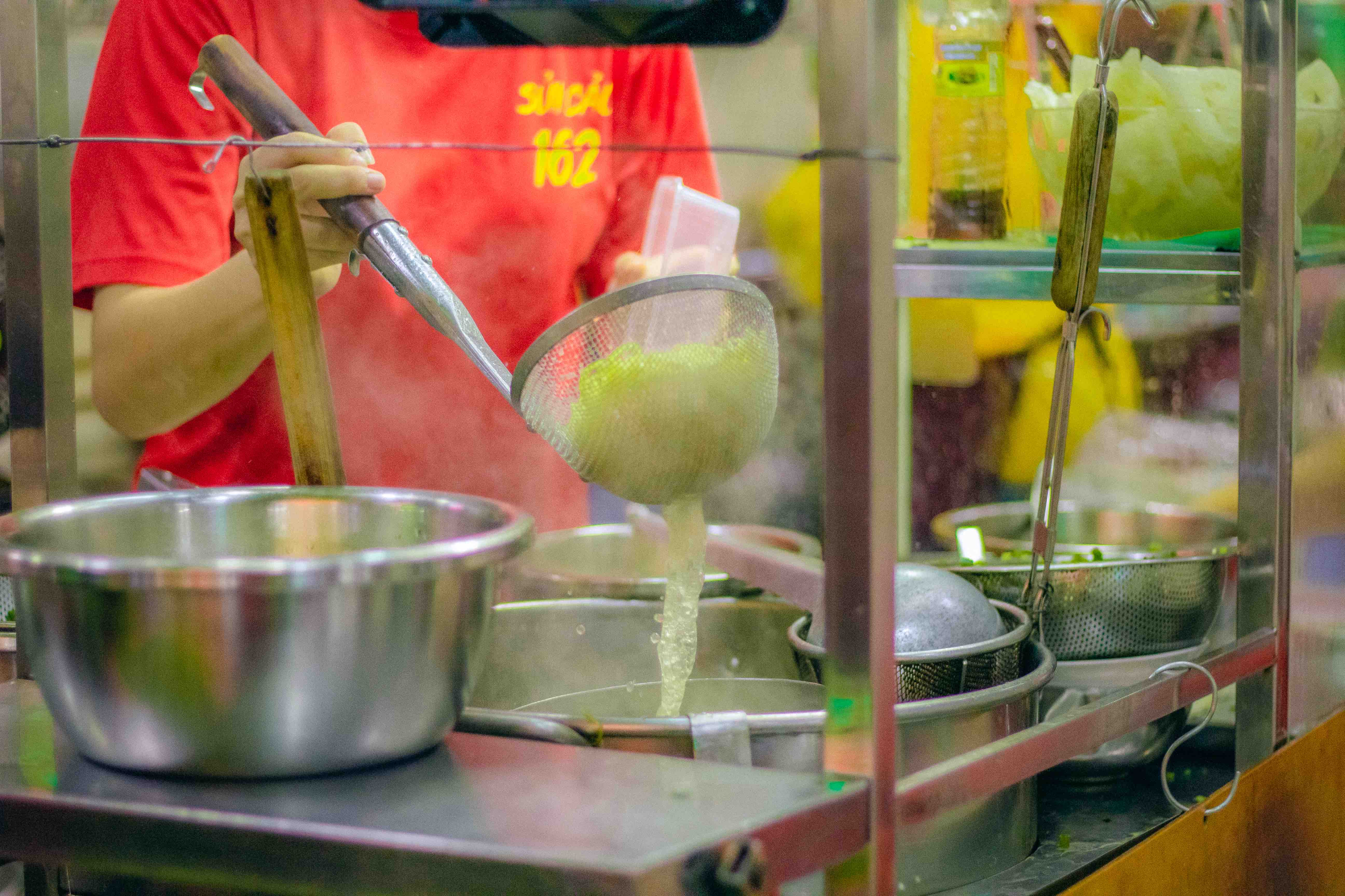 A woman prepares shuijiao with golden egg noodles at a stall on Ha Ton Quyen Street, District 11, Ho Chi Minh City. Photo: Linh To / Tuoi Tre News