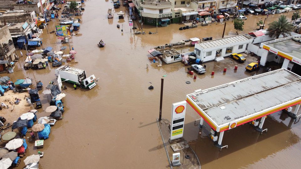 An aerial view shows residents making their way through a flooded street after heavy rains in Yoff district of Dakar, Senegal July 20, 2022. Photo: Reuters