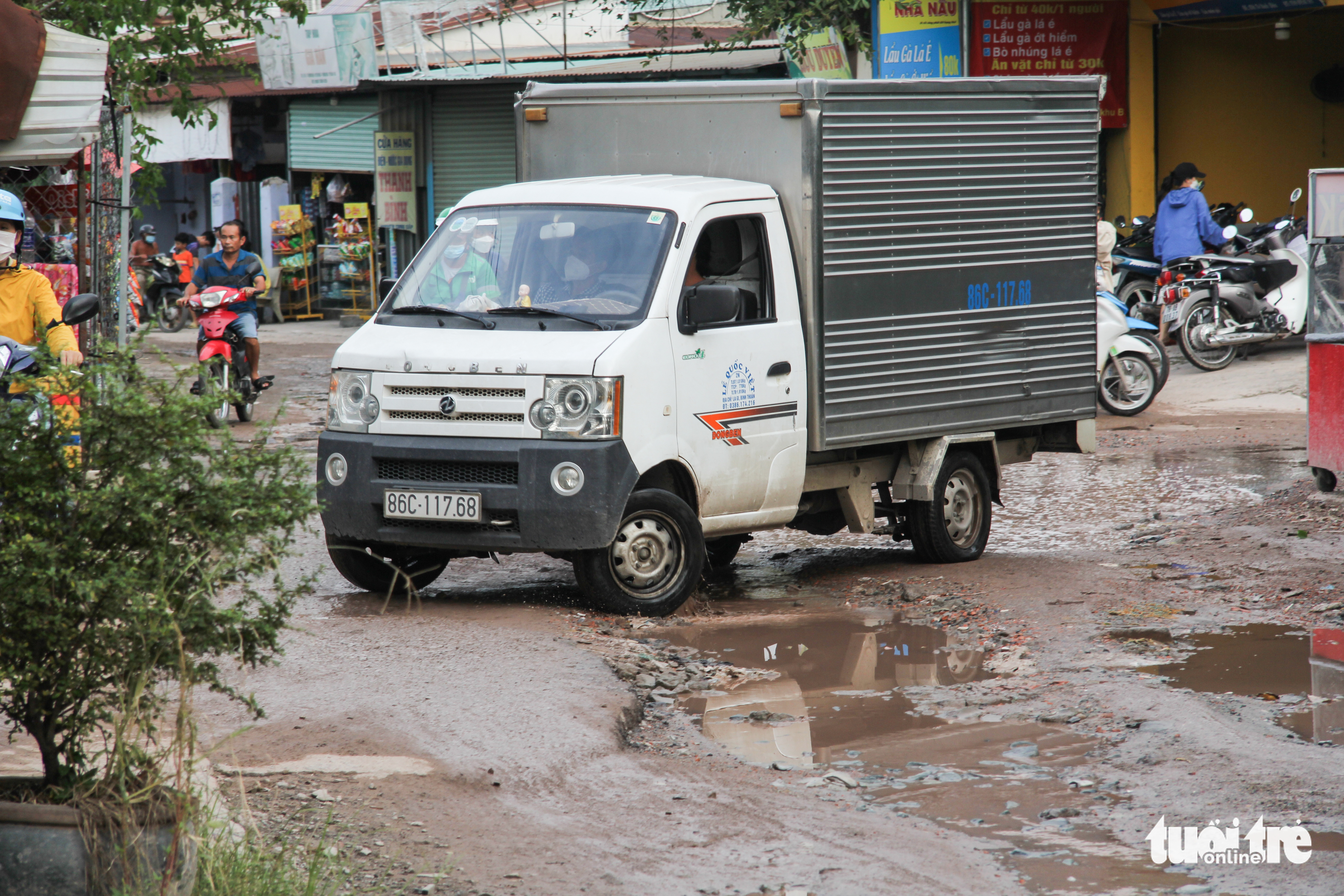 A mini truck is to turn away after facing giant potholes on To Vinh Dien Street in the complex of universities under the Vietnam National University-Ho Chi Minh City in Binh Duong Province, Vietnam. Photo: Kieu Hanh / Tuoi Tre