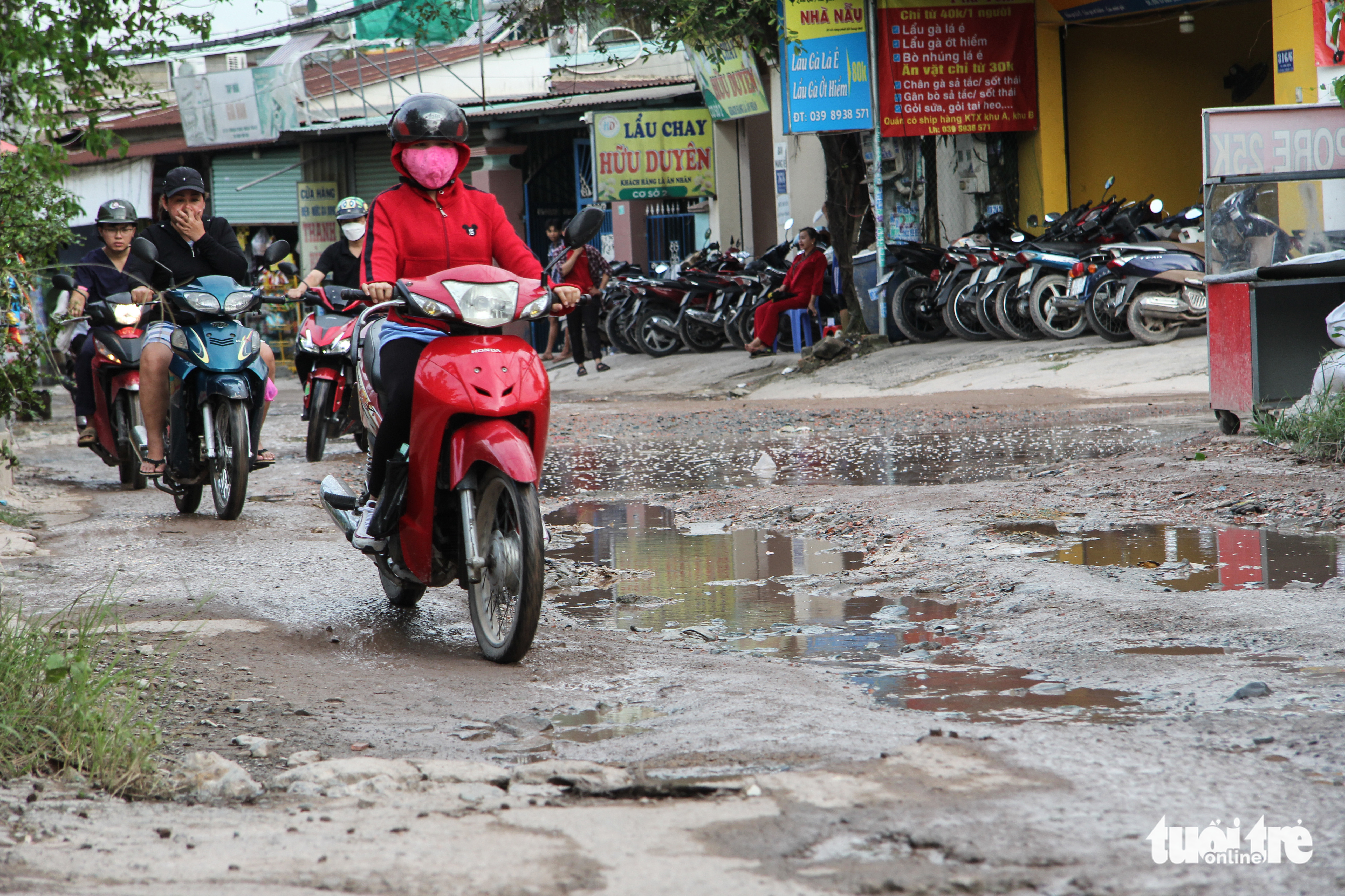 Motorcyclists travel on the degraded To Vinh Dien Street in the complex of universities under the Vietnam National University-Ho Chi Minh City in Binh Duong Province, Vietnam. Photo: Kieu Hanh / Tuoi Tre