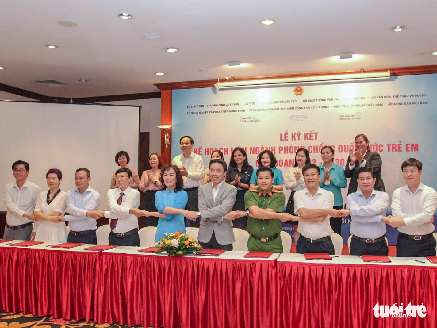 Delegates shake hands during the signing ceremony of a joint effort among ten ministries and agencies to prevent child drownings in the 2022-30 period in Vietnam, July 25, 2022. Photo: Ha Quan / Tuoi Tre