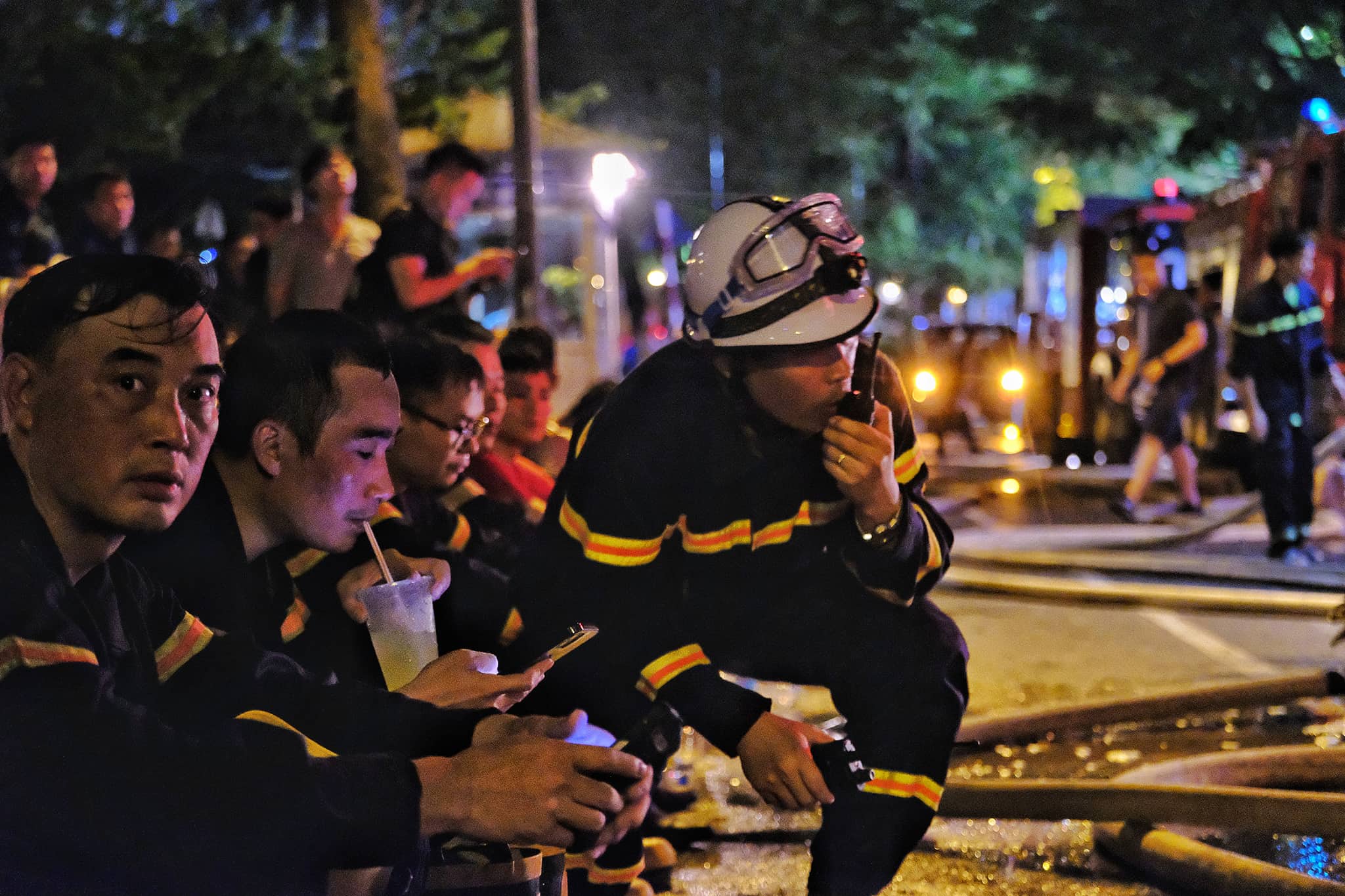 Many firefighters are exhausted after extinguishing a blaze that broke out on the fifth floor of a karaoke parlor in Cau Giay District, Hanoi, August 1, 2022. Photo: Nam Tran / Tuoi Tre