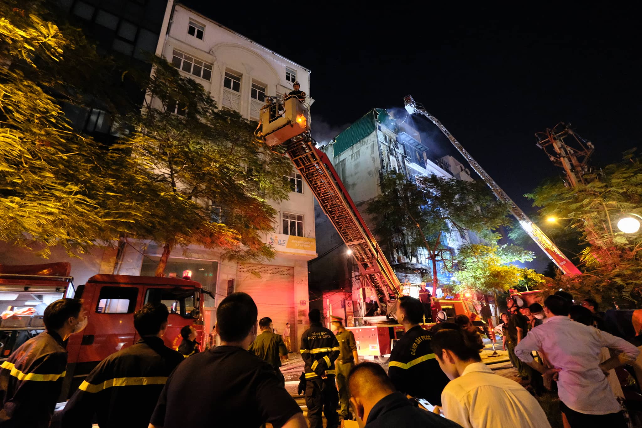 Firefighters use a fire ladder to approach a blaze that broke out on the fifth floor of a karaoke parlor in Cau Giay District, Hanoi, August 1, 2022. Photo: Nam Tran / Tuoi Tre