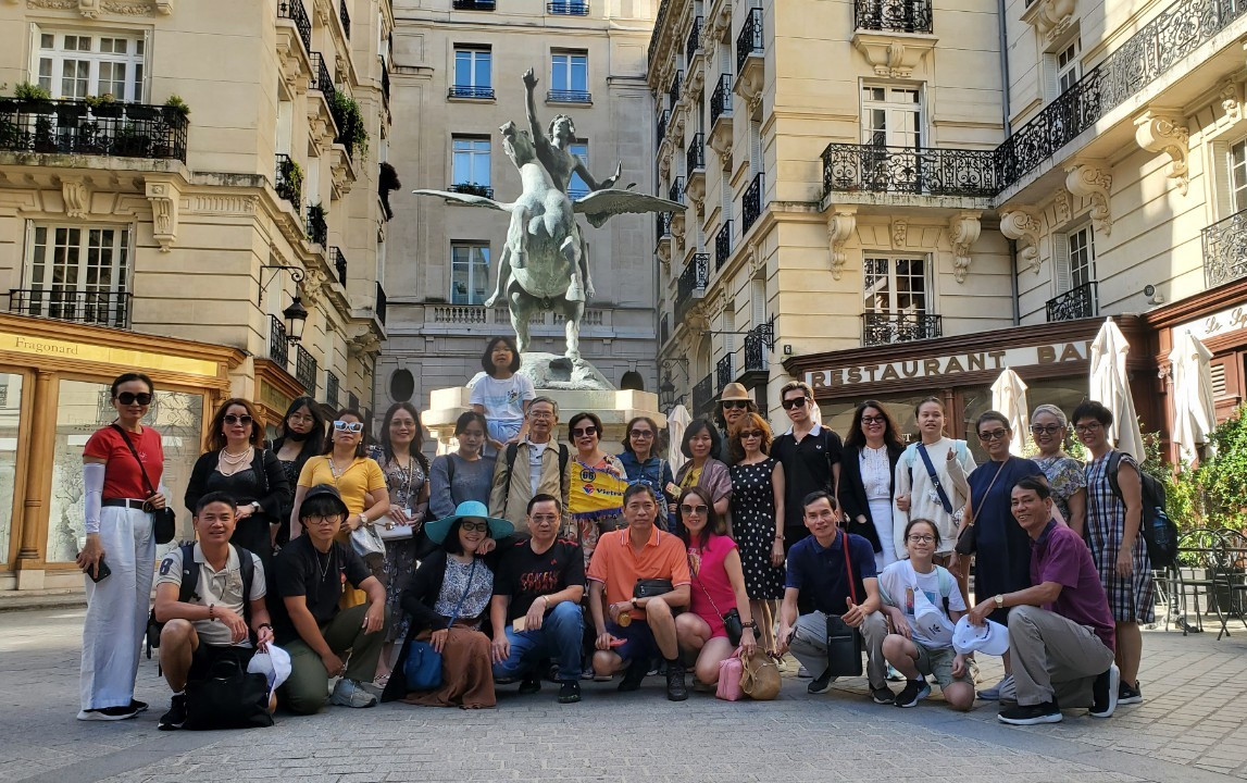 A group of Vietnamese tourists pose for a photo in Paris, France. Photo: Nguyen Minh / Tuoi Tre