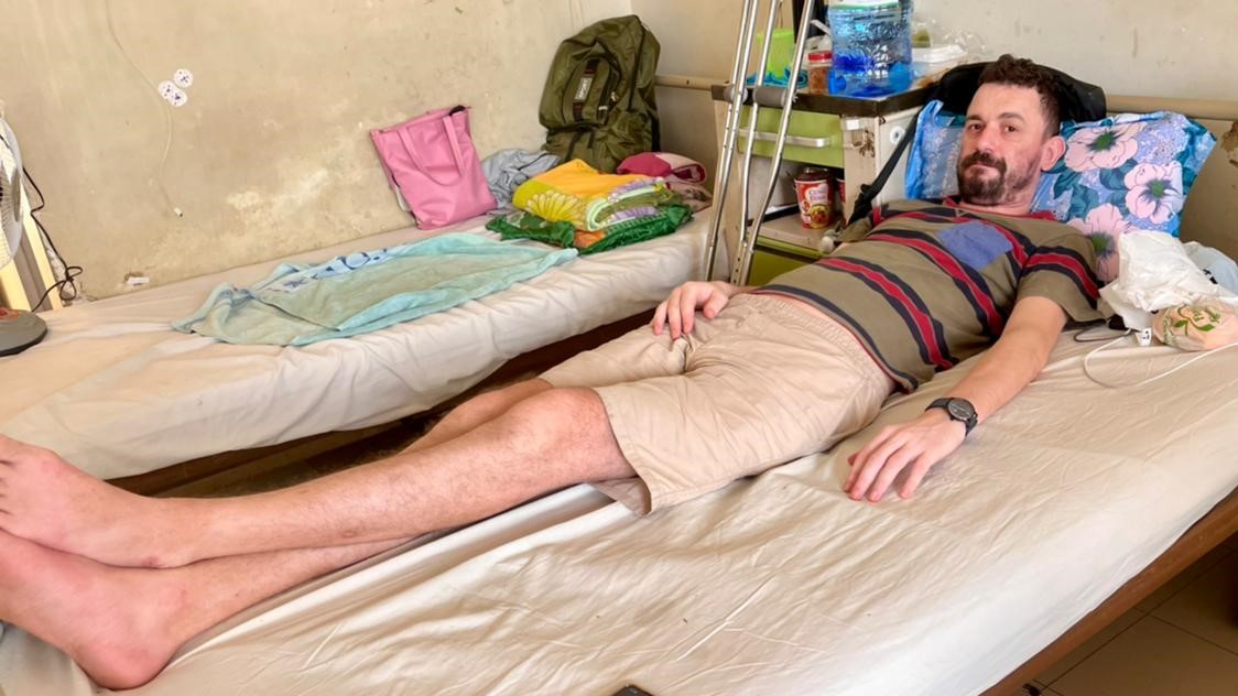 Roman Borodachev lies on his bed due to his femoral neck fracture in Khanh Hoa Province, Vietnam. Photo: Anna Los