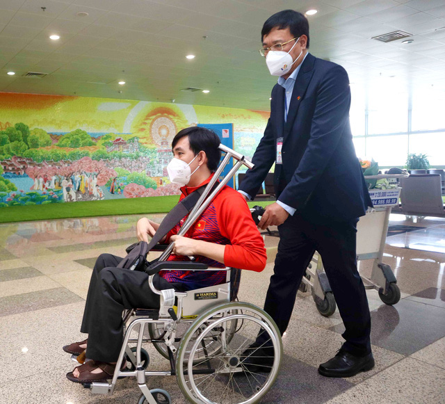 Dang Ha Viet, the general director of the General Department of Sports and Physical Training, escorts a mobility-impaired athlete upon their return at Noi Bai International Airport in Hanoi on August 7, 2022 following the conclusion of the 2022 Southeast Asian Para Games (ASEAN Para Games) in Indonesia. Photo: Quy Luong / Tuoi Tre