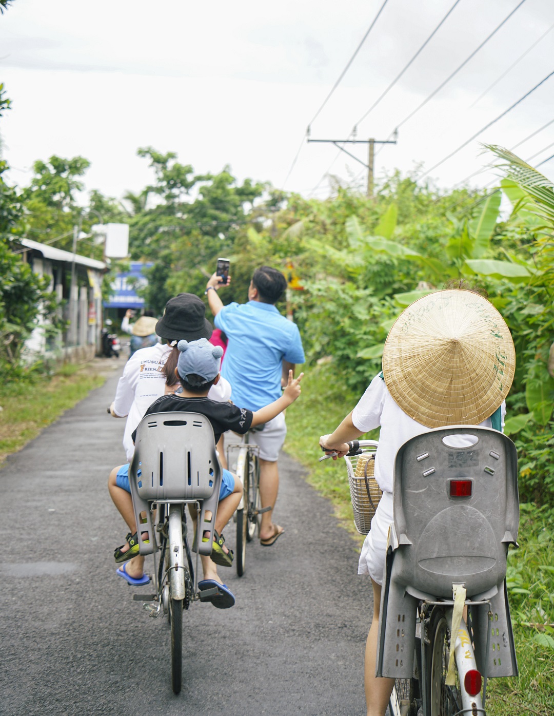 Tourists ride bicycles around Tan Phong Island. Most of roads are concrete, facilitating the travel. Photo: Nguyen Trung Au / Tuoi Tre News