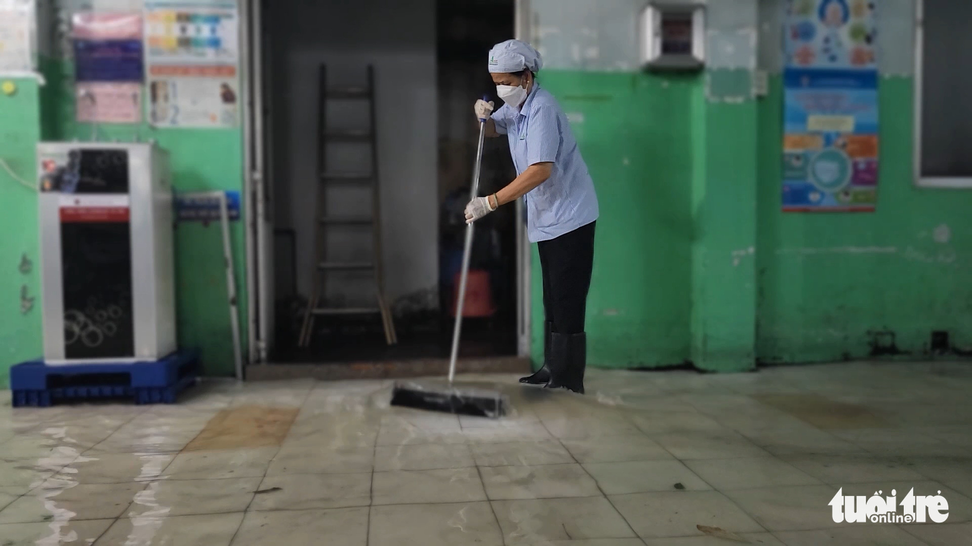 A janitor picks rubbish at the inundated Hoc Mon General Hospital in Hoc Mon District, Ho Chi Minh City, August 15, 2022. Photo: Ngoc Khai / Tuoi Tre