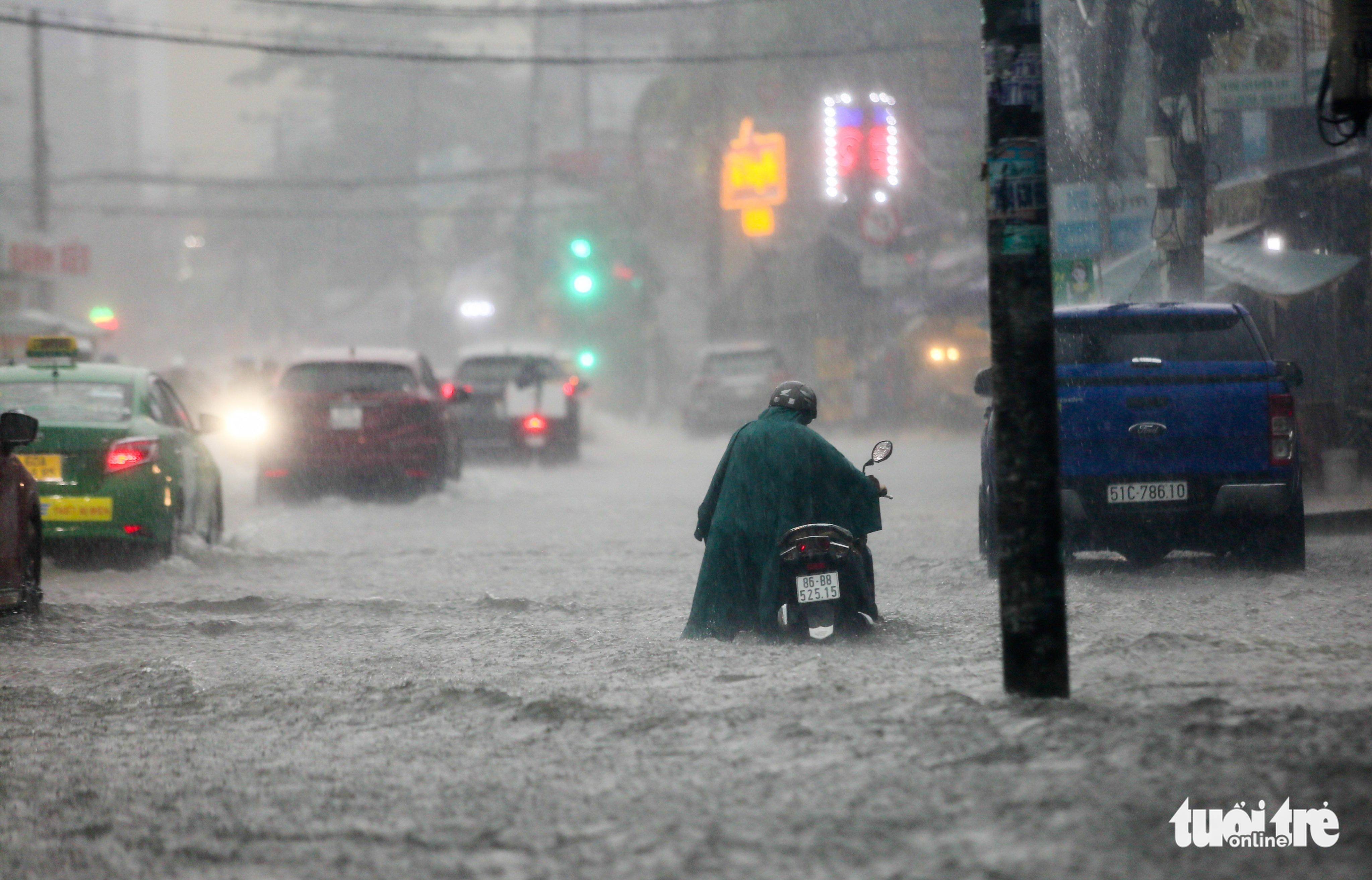 A resident pushes a motorbike on a flooded street in Ho Chi Minh City, August 15, 2022. Photo: Le Phan / Tuoi Tre