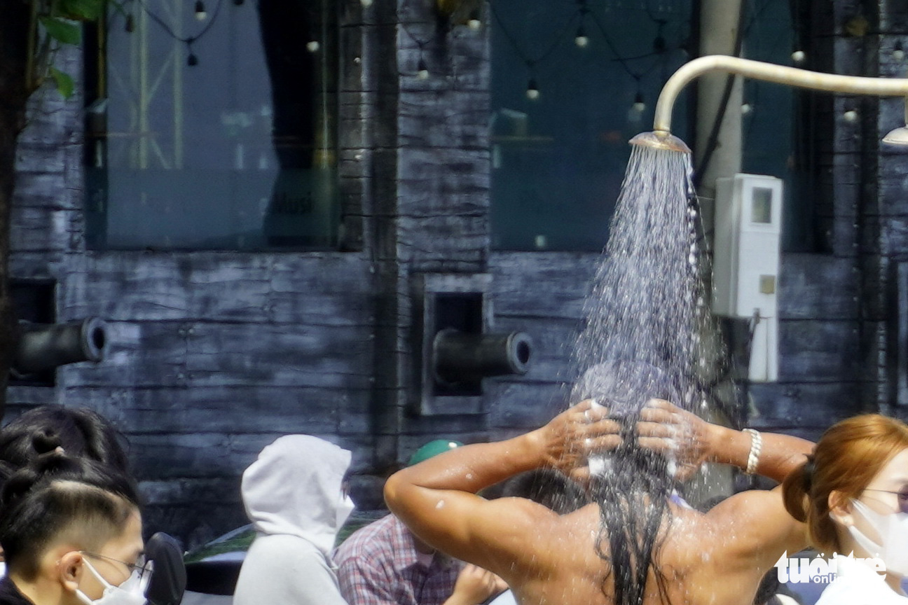 A beachgoer washes with shampoo at a public beach shower in Vung Tau City, Ba Ria-Vung Tau Province, August 16, 2022. Photo: Dong Ha / Tuoi Tre