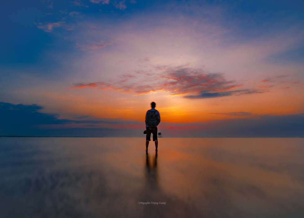 A man poses against the sunrise at Thuy Xuan Beach, Thai Thuy District, Thai Binh Province, northern Vietnam. Photo: Nguyen Trong Cung / Tuoi Tre