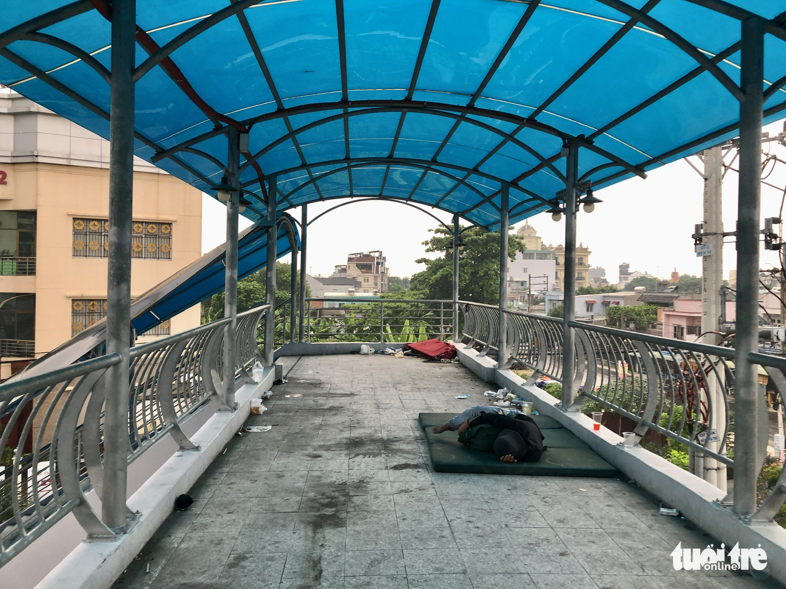 A homeless person sleeps on a footbridge crossing National Highway 22 near An Suong Bus Station in Ho Chi Minh City. Photo: Chau Tuan / Tuoi Tre
