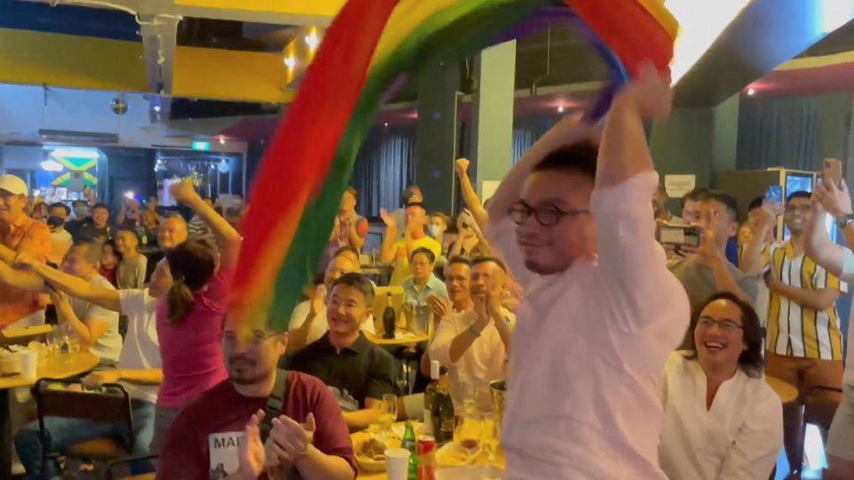 A man waves a rainbow flag after Singapore's Prime Minister Lee Hsien Loong announces that Singapore will decriminalise gay sex, in Singapore, August 21, 2022, this screen grab obtained from a social media video. Boo Junfeng/via Reuters