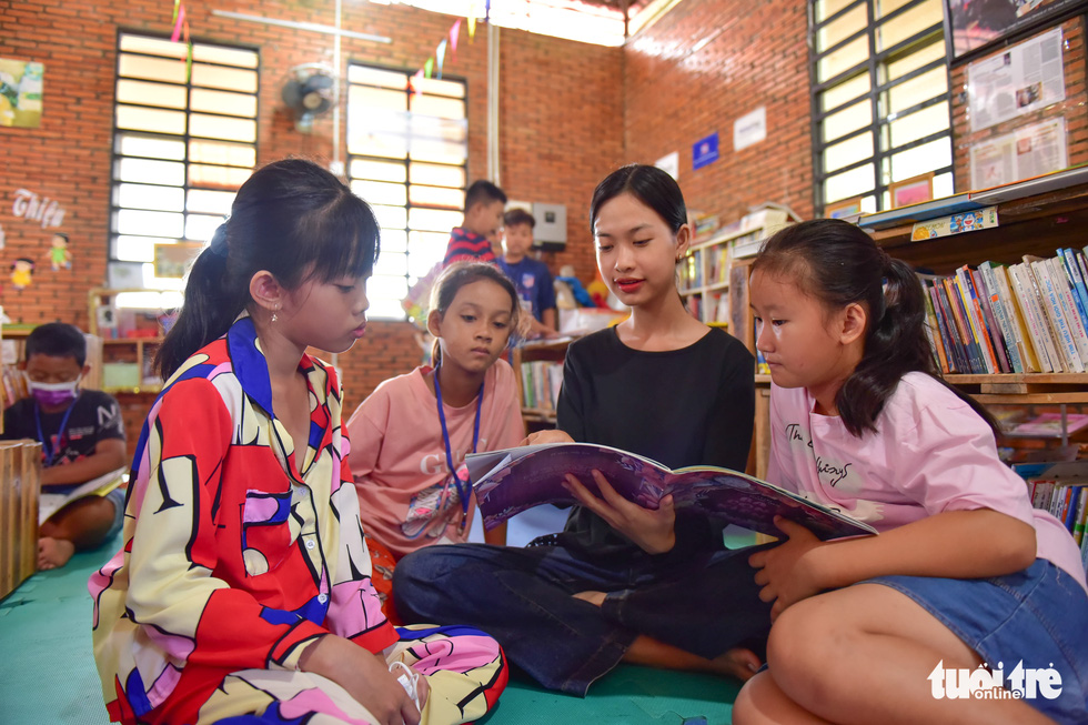 In her spare time, Dan Y Lien Hoa often reads and tells stories to local kids in her village. Photo: Ngoc Phuong / Tuoi Tre