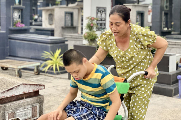 They currently live inside a cemetery where they share a 10-square-meter room. She takes him out on a wheelchair ride every day. Photo: Dieu Qui / Tuoi Tre