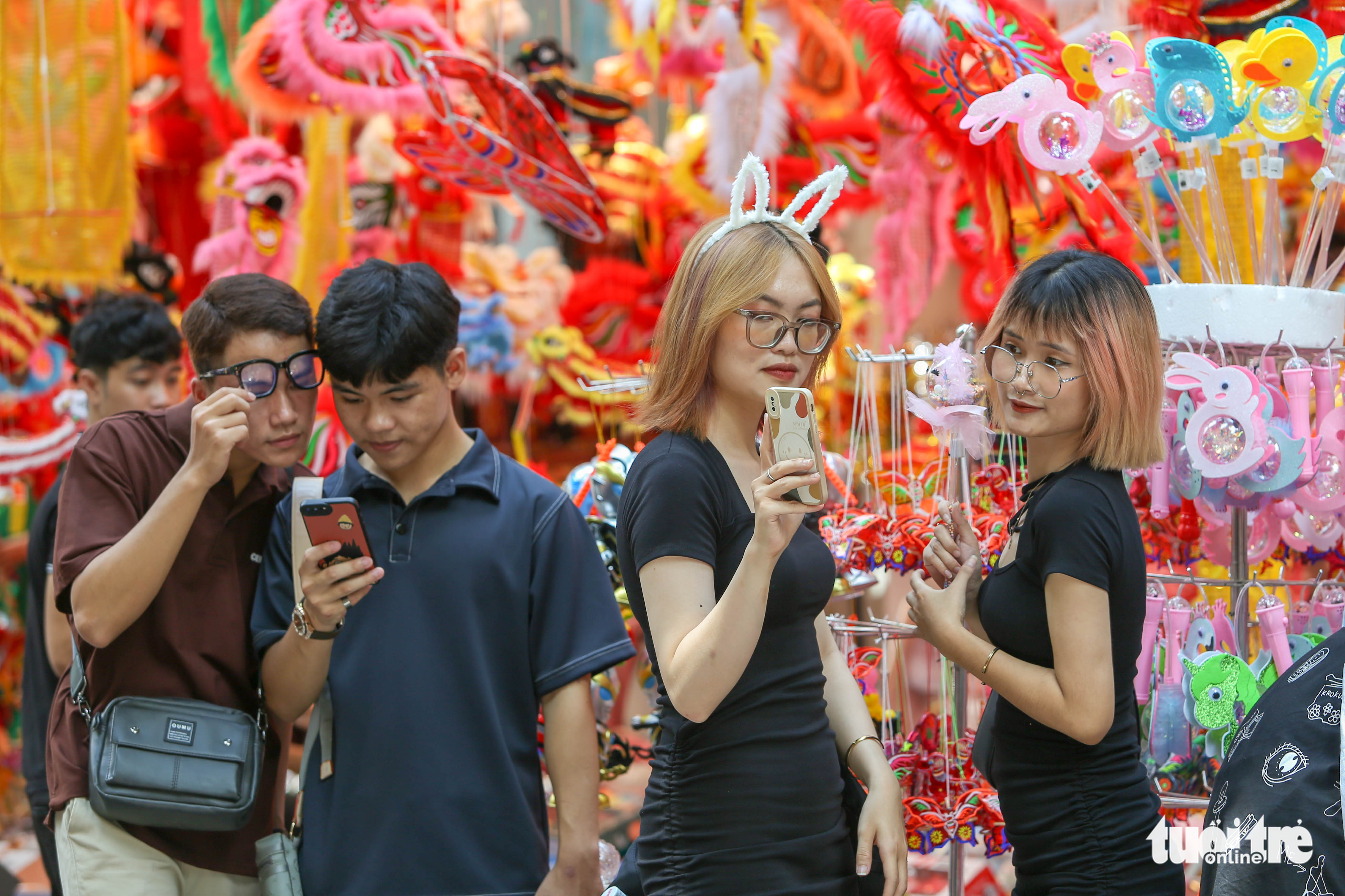 Young people take selfies with lanterns on Hang Ma Street in Hanoi. Photo: Ha Quan / Tuoi Tre