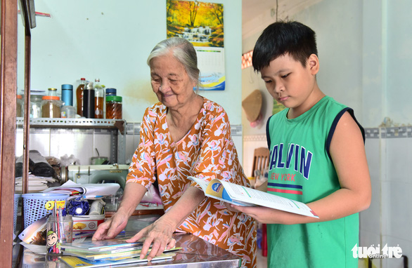 Dao Le Thien Phuc, a student of Thanh Da Middle School in Binh Thanh District, Ho Chi Minh City and his grandmother are seen arranging textbooks and notebooks before returning to school. Photo: Duyen Phan / Tuoi Tre