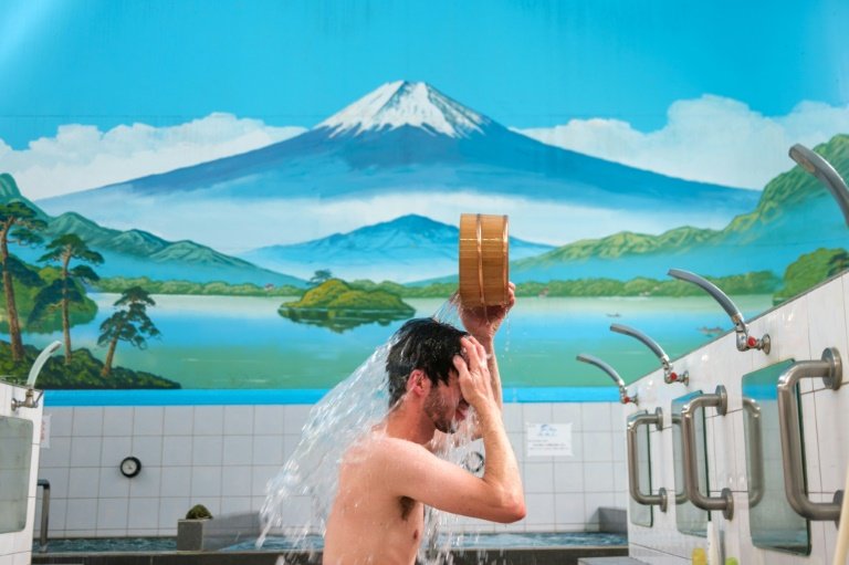 Japan has never imposed a strict COVID-19 lockdown, and places such as gyms and sentos remained open even when many offices switched to home working and restaurants shortened opening hours. Photo: AFP