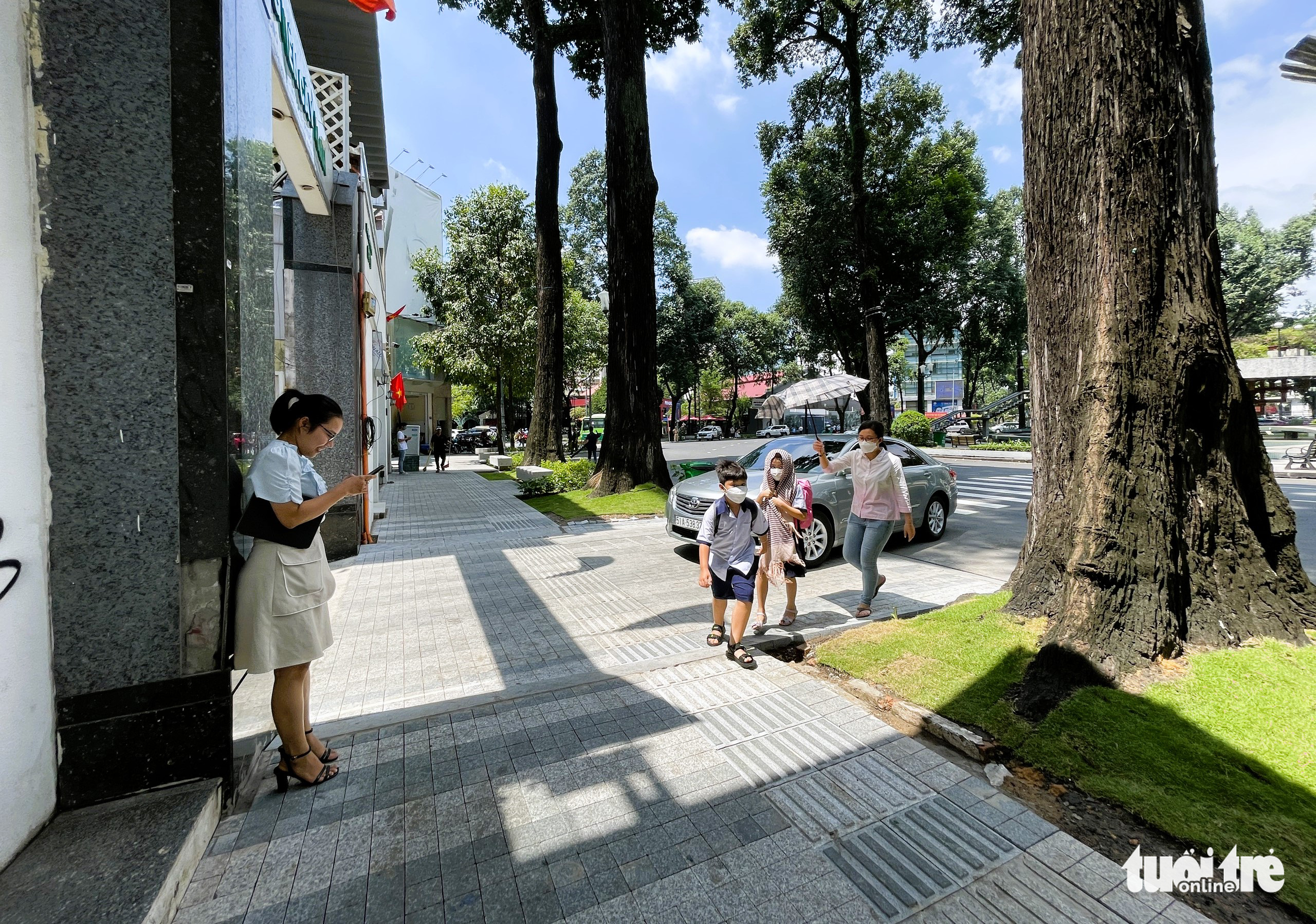 People walk on the renovated sidewalk surrounding Ho Con Rua (Turtle Lake) in downtown Ho Chi Minh City, August 31, 2022. Photo: Le Phan / Tuoi Tre