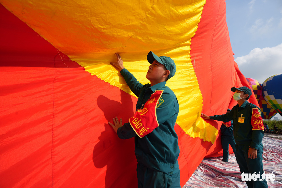 Some of the 120-member crew in charge of the pulling the national flags using two hot air balloons in Ho Chi Minh City on September 2, 2022 are seen in this image. Photo: Huu Hanh / Tuoi Tre