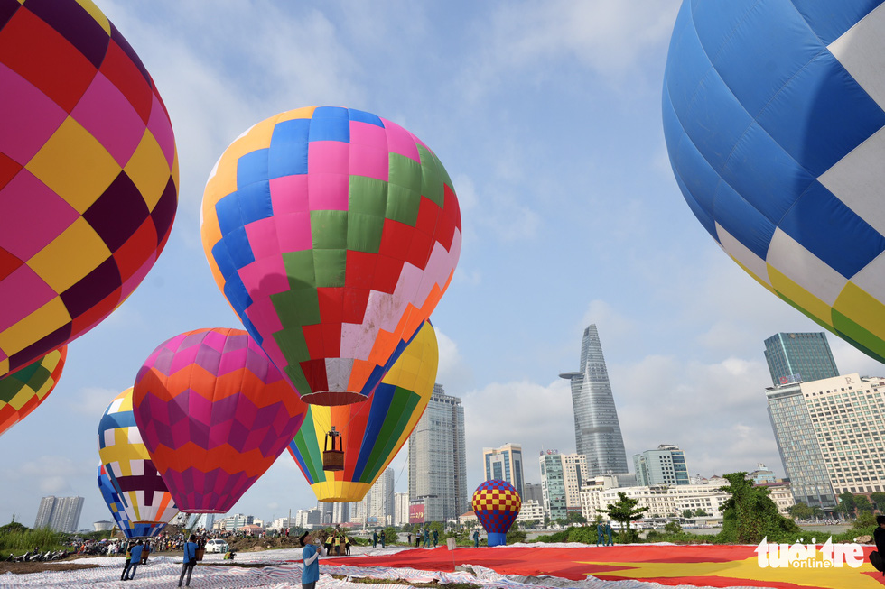 This image shows the eight smaller hot air balloons being about to release into the sky along with the two larger ones that pull the Vietnamese national flag on September 2, 2022 in Ho Chi Minh City. Photo: Huu Hanh / Tuoi Tre