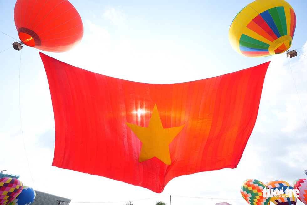 This image shows the Vietnamese national flag fully stretching after being raised into the sky in Ho Chi Minh City on September 2, 2022. Photo: Huu Hanh / Tuoi Tre