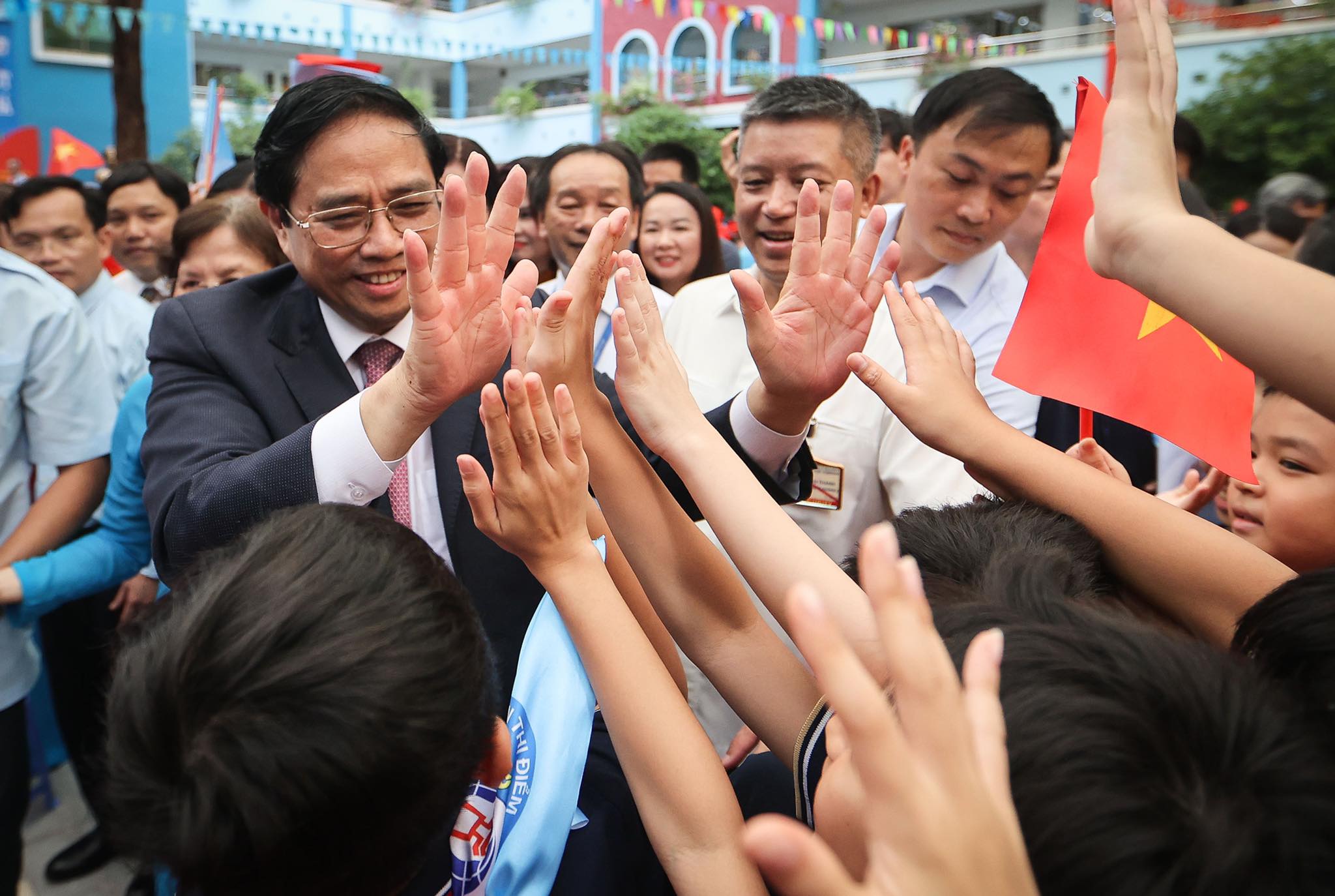 Prime Minister Pham Minh Chinh high-fives students before the school opening ceremony at Doan Thi Diem Elementary School in Hanoi, September 5, 2022. Photo: Nguyen Khanh / Tuoi Tre