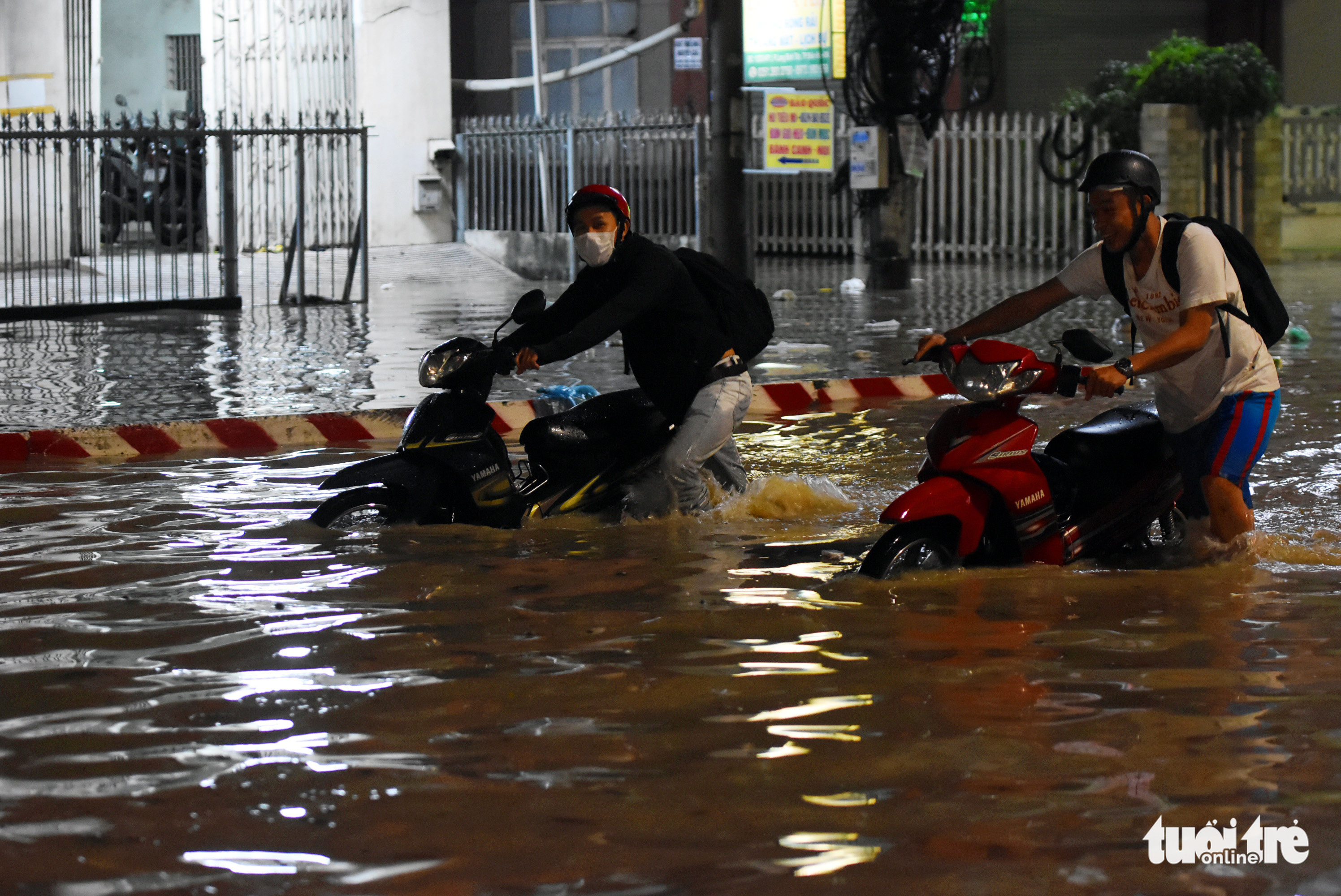 Residents push their broken-down motorbikes along a flooded section of National Highway No.51 in Dong Nai Province, Vietnam, September 6, 2022. Photo: A Loc / Tuoi Tre