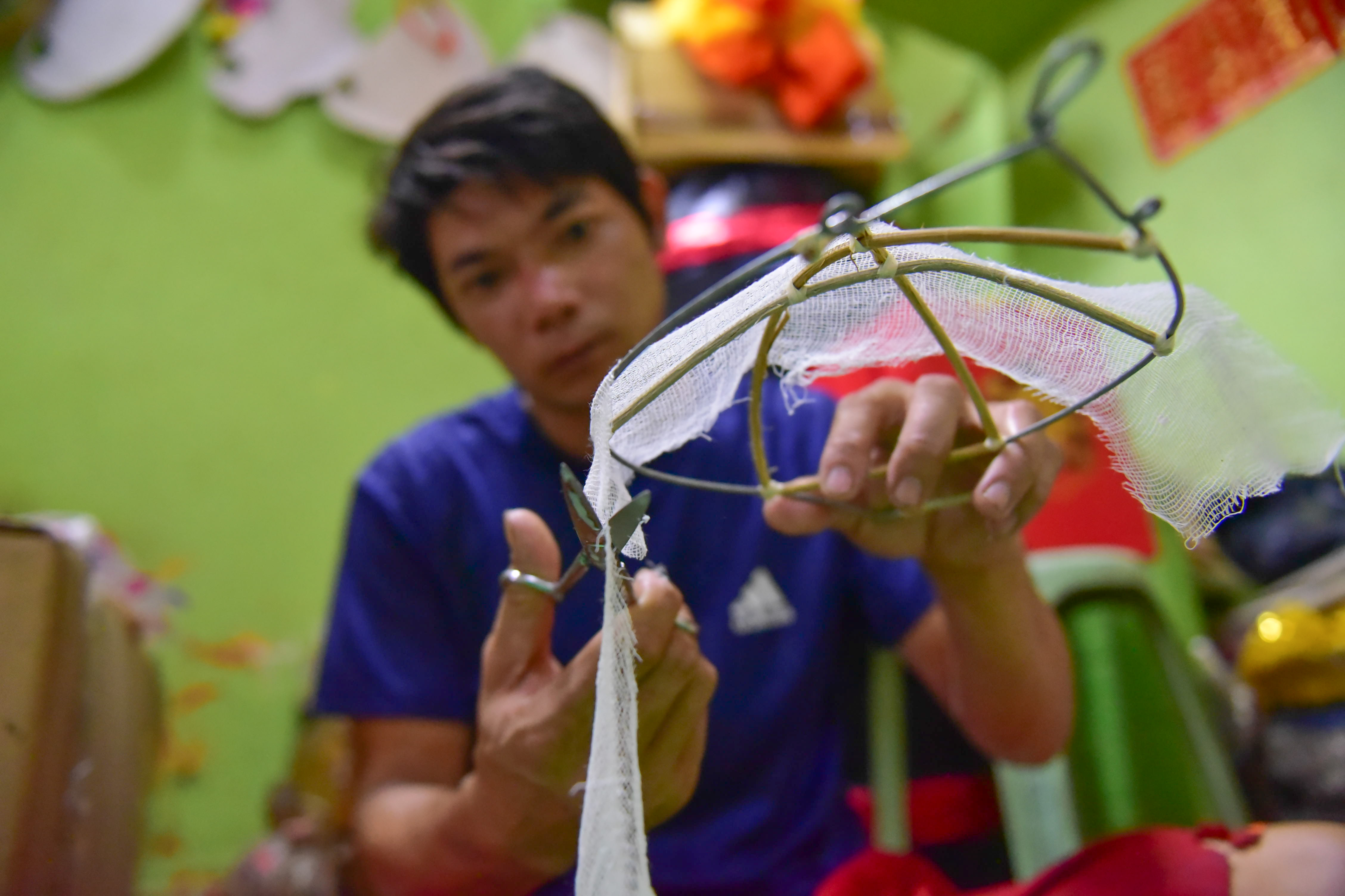 Chi Quyen, an artisan at Banh Chi Hung’s facility, covers a lion ear with fabric. Photo: Ngoc Phuong / Tuoi Tre News
