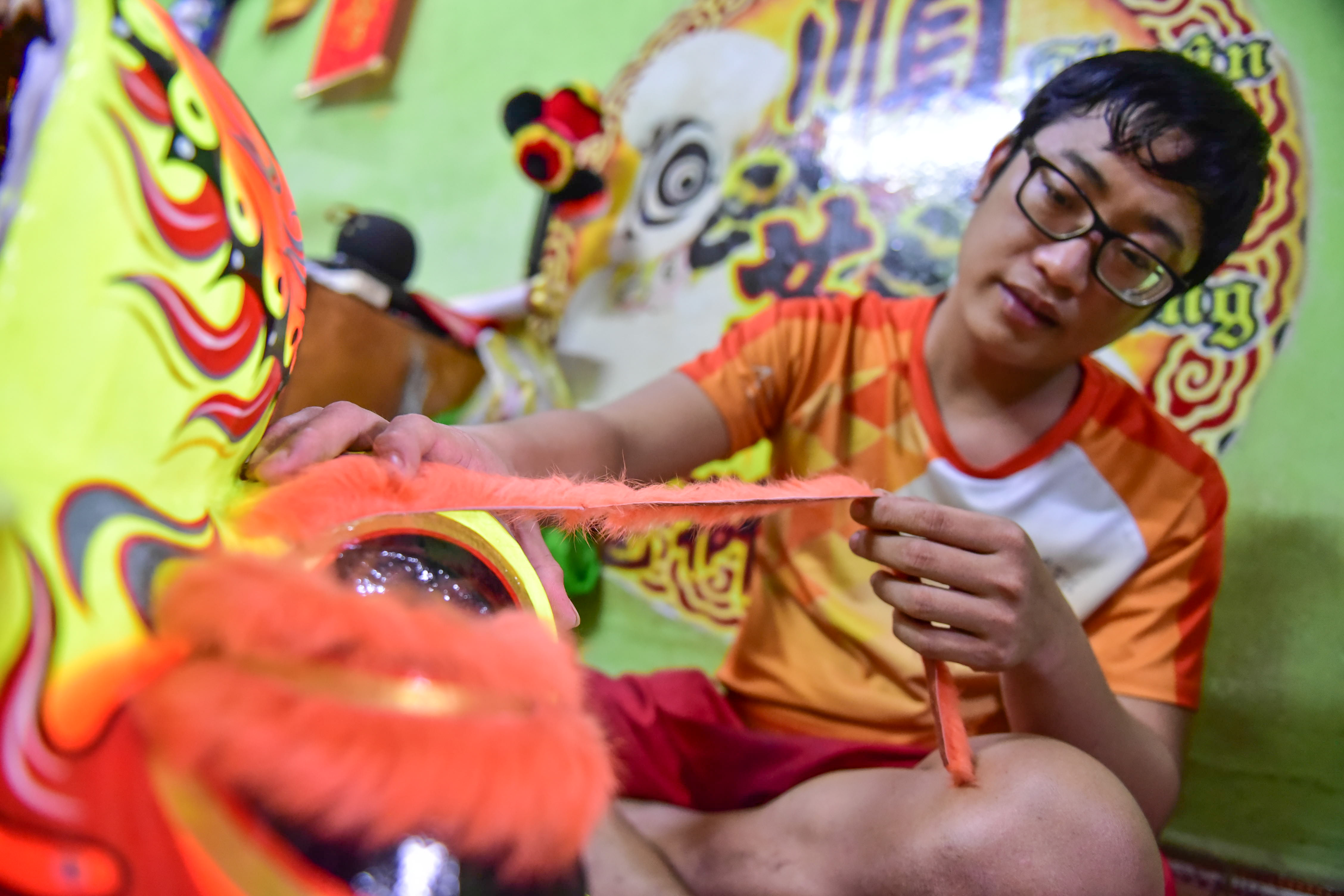 A craftsman decorates lion heads with fur to make them more animated and attractive. Photo: Ngoc Phuong / Tuoi Tre News