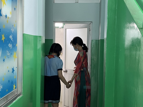 A teacher guides a student to a bathroom dedicated for female to use during their menstrual periods at Le Dinh Chinh Elementary School in District 10, Ho Chi Minh City, September 7, 2022. Photo: My Dung / Tuoi Tre
