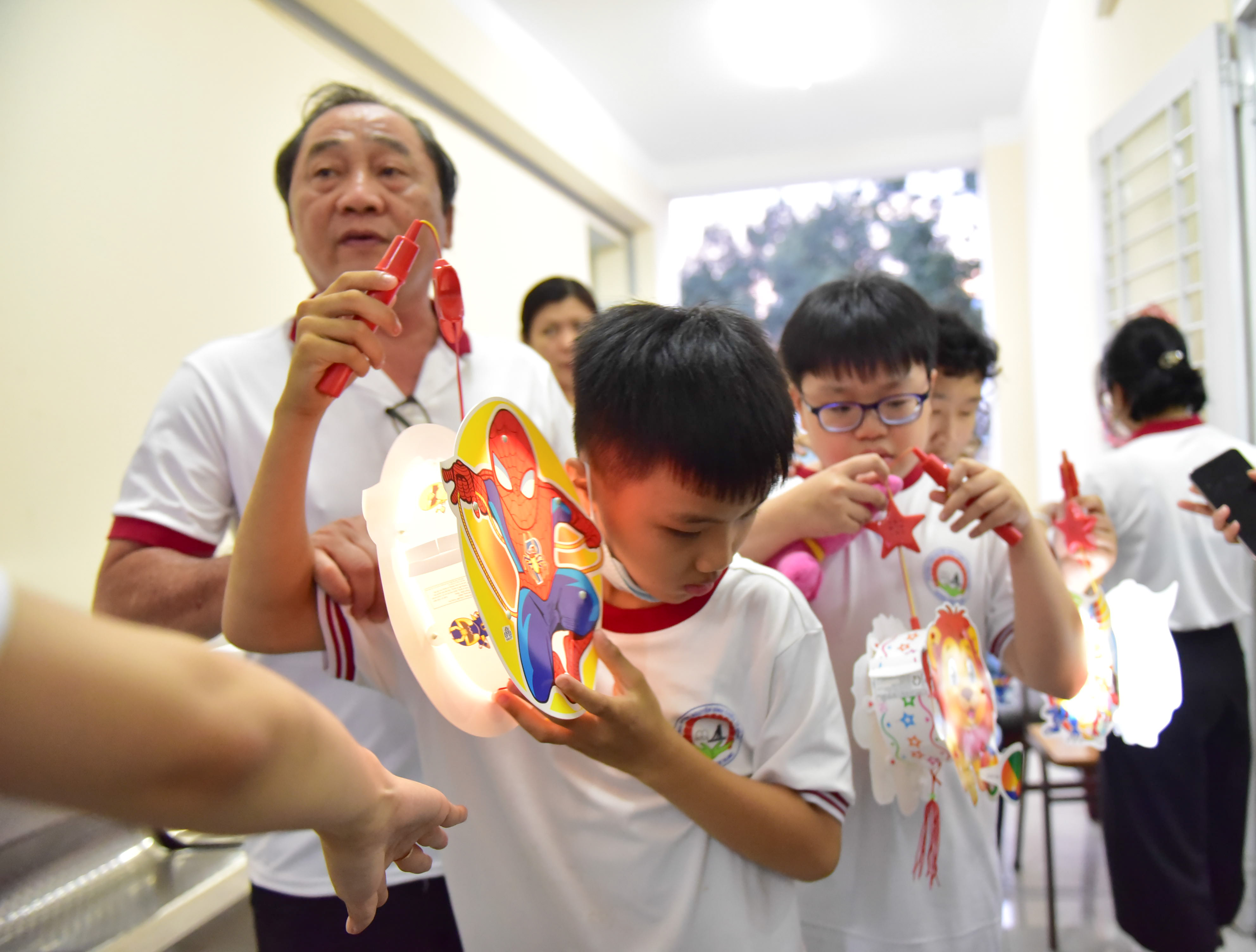 A student listens to music from an electronic lantern before participating in a lantern parade to celebrate the Mid-Autumn Festival held by Nguyen Dinh Chieu Special School for the Blind in District 10, Ho Chi Minh City on September 9, 2022. Photo: Ngoc Phuong / Tuoi Tre News