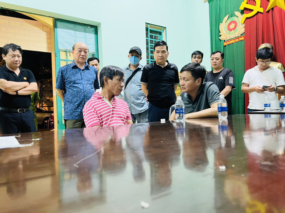This supplied photo shows the bank robbery suspect being questioned by a police officer in Dong Nai Province after his arrest on September 11, 2022.