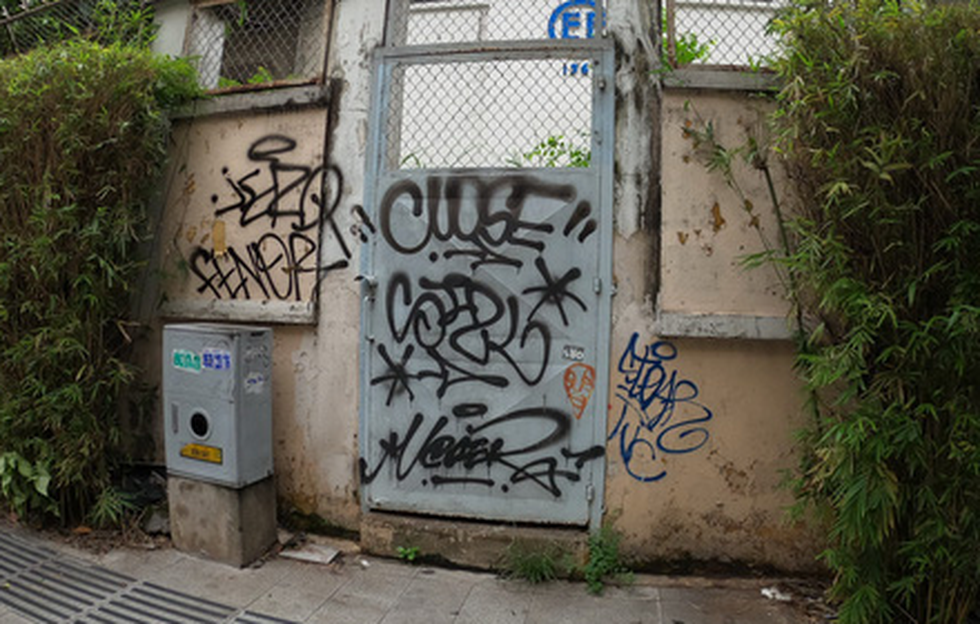 The gate of an agency on Hai Ba Trung Street in District 1 is covered with graffiti. Photo: H.L. / Tuoi Tre