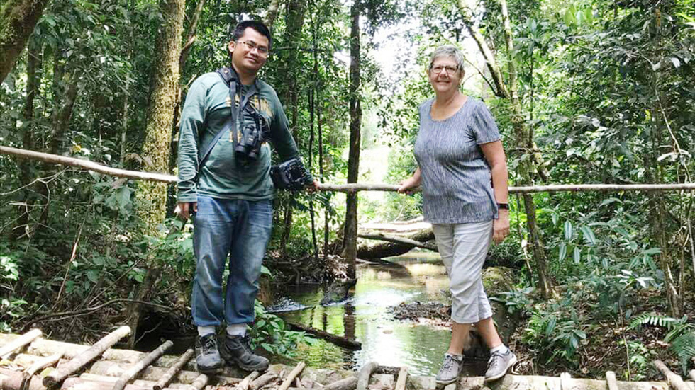 Nguyen Anh The takes a visitor to the forest to watch birds. Photo: Andy Nguyen / Tuoi Tre