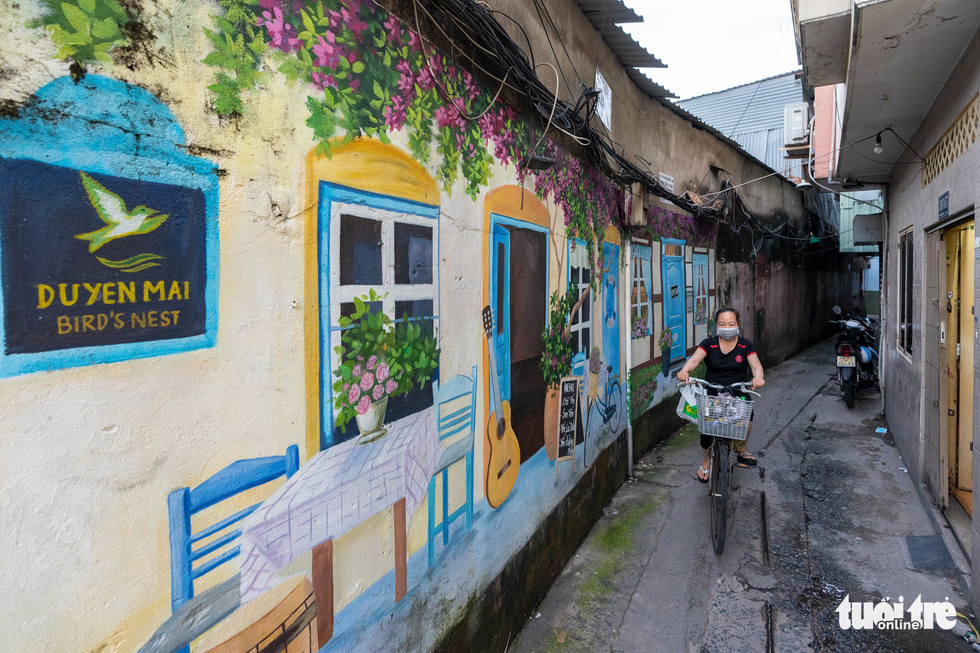 Thanh Duyen, a resident in District 3, has an artist paint a picture on the front wall of his house on Tran Van Dang Street. Photo: Huu Hanh / Tuoi Tre