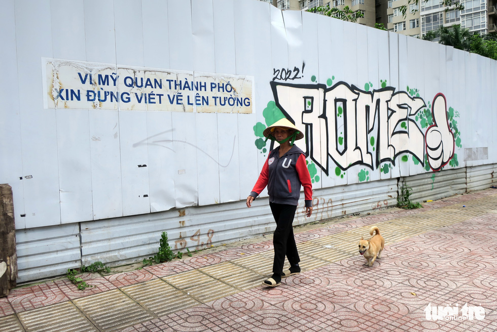 The motto “For the city’s beauty, please do not write or paint on wall” on steel sheets at a construction site near the Thu Thiem 1 Bridge in Binh Thanh District makes no difference to graffiti drawers. Photo: T.T.D. / Tuoi Tre