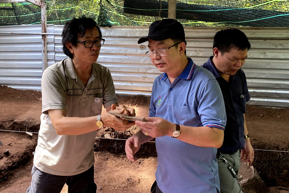 Dang Van Thang (left) introduces a piece of Olive ridley sea turtle’s shell, which is a pottery making tool of ancient people in Can Gio. Photo: L.Dien / Tuoi Tre
