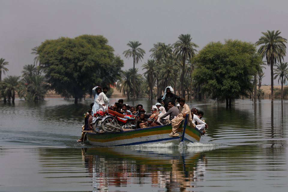 Flood victims travel in a boat, following rains and floods during the monsoon season in Talti town in Sehwan, Pakistan September 15, 2022. Photo: Reuters