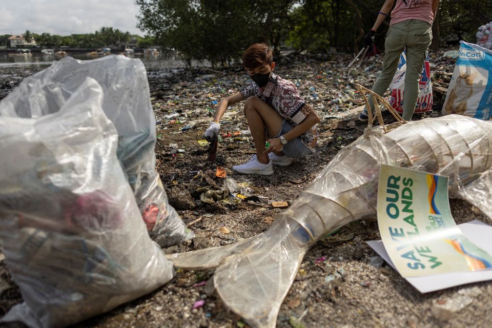 Volunteers pick up trash during a coastal cleanup drive at a protected bird sanctuary, ahead of the international coastal cleanup day in Paranaque City, Philippines, September 16, 2022. Photo: Reuters