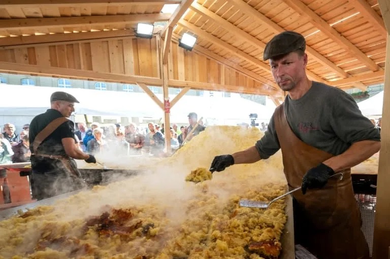 Once cooked, portions of the giant fritter were served to the large crowd gathered to witness the feat. Photo: AFP