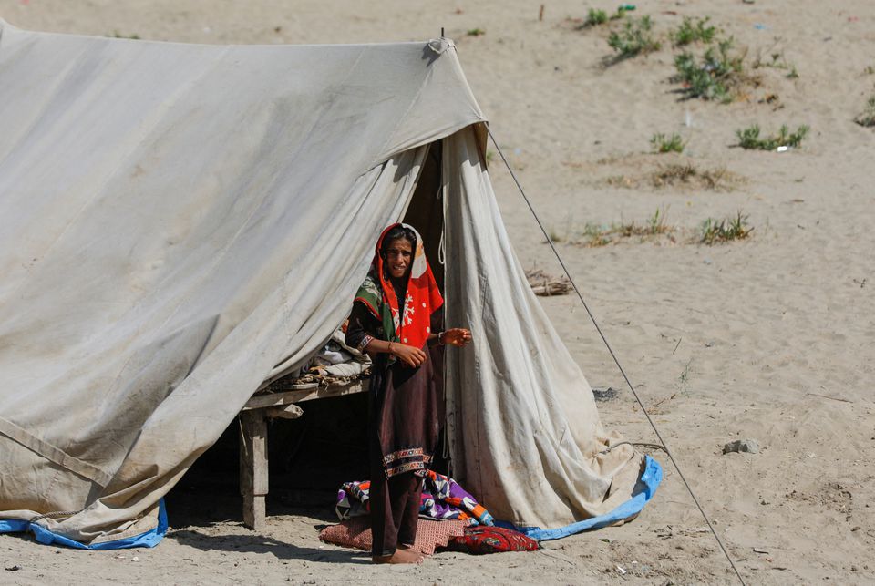 A displaced woman stands at her family tent in a camp, following rains and floods during the monsoon season in Sehwan, Pakistan, September 16, 2022. Photo: Reuters