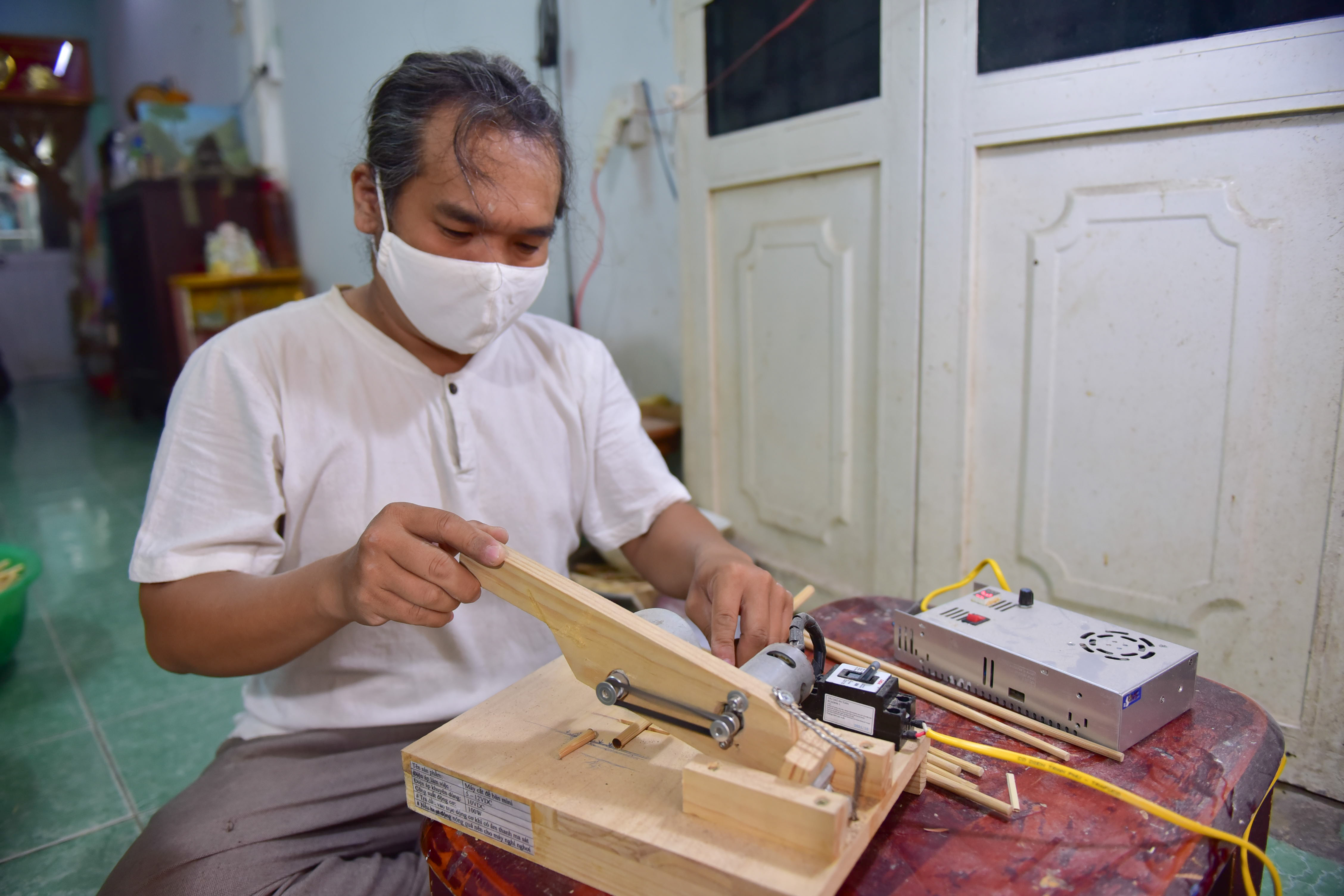 Phan cuts bamboo chopsticks to make pen tips. Photo: Ngoc Phuong / Tuoi Tre News