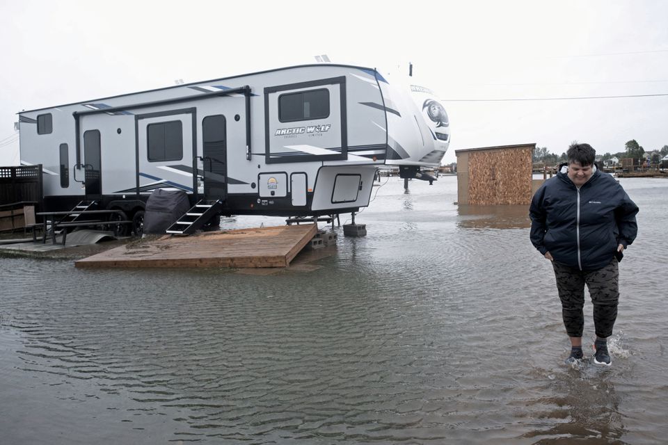 Cathy Simpkins of Moncton walks through flood waters to check her recreational vehicle trailer following the passing of Hurricane Fiona, later downgraded to a post-tropical cyclone, in Shediac, New Brunswick, Canada September 24, 2022. Photo: Reuters