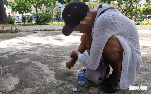 A lottery ticket seller injects narcotics into his bloodstream at 23/9 Park in District 1, Ho Chi Minh City, September 23, 2022. Photo: Minh Hoa / Tuoi Tre