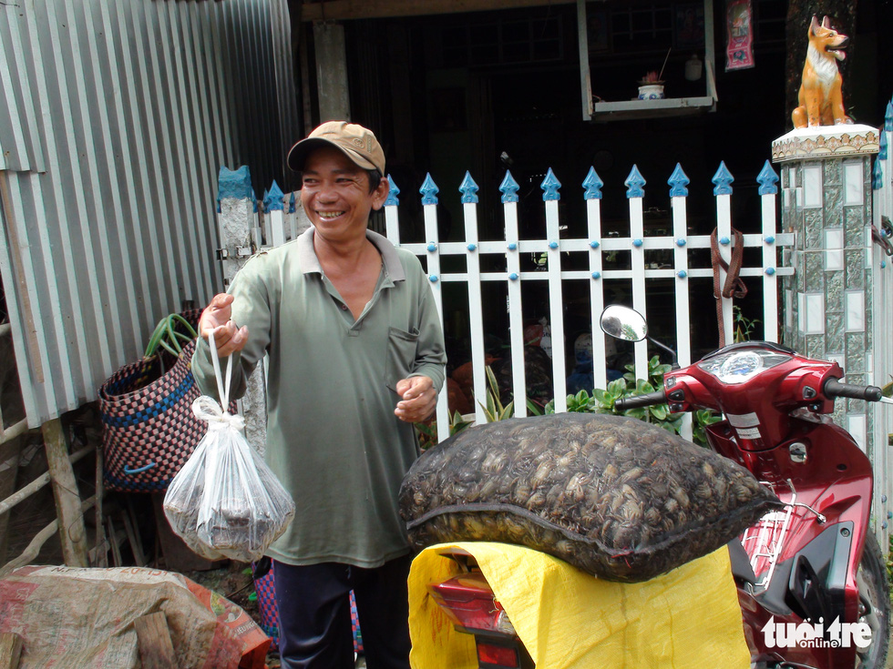 A fisherman is carrying his 30 kilograms of field crabs to a wholesaler.
