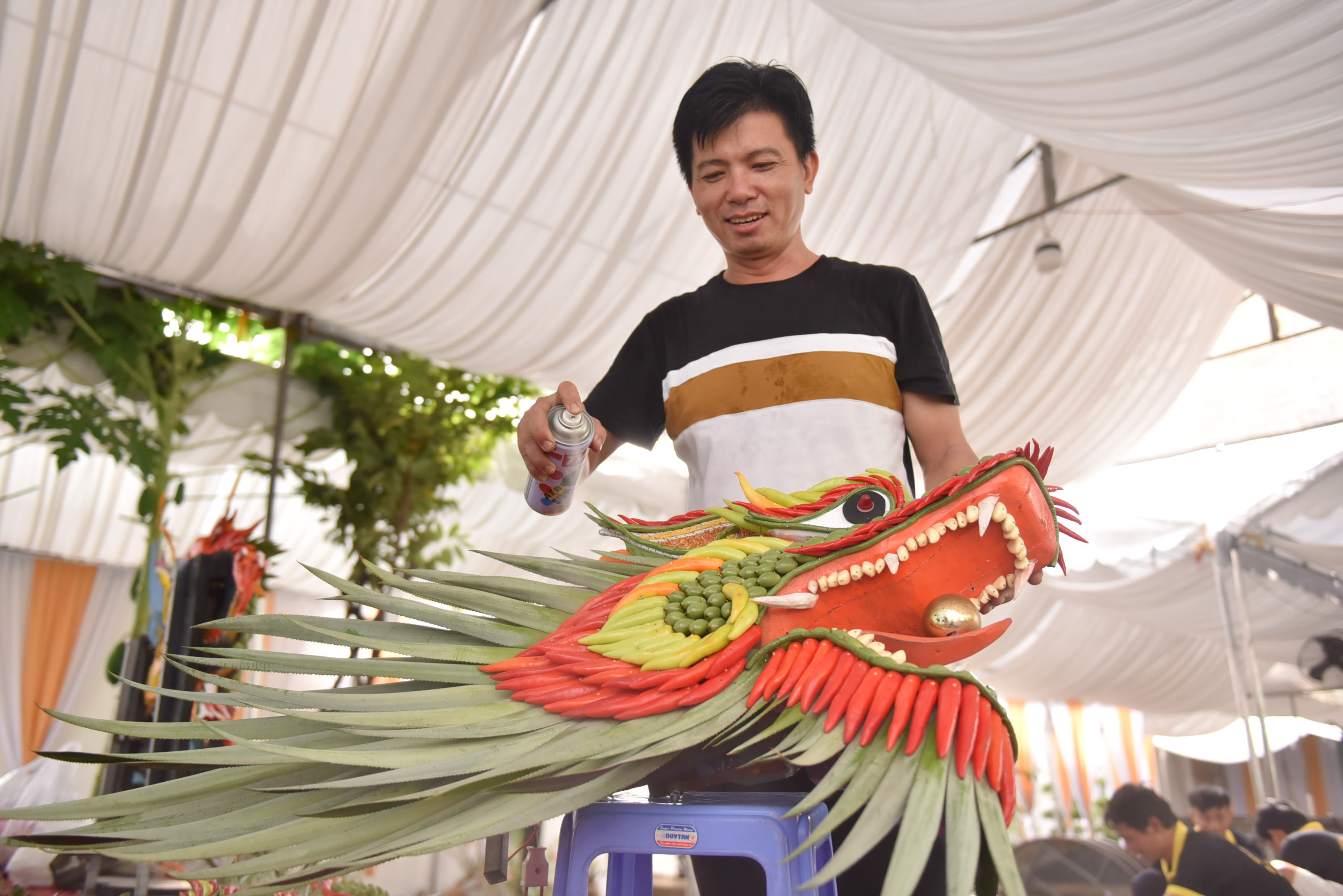 Tran Trung Hieu glazes the dragon head to make it shiny. Photo: Ngoc Phuong / Tuoi Tre News