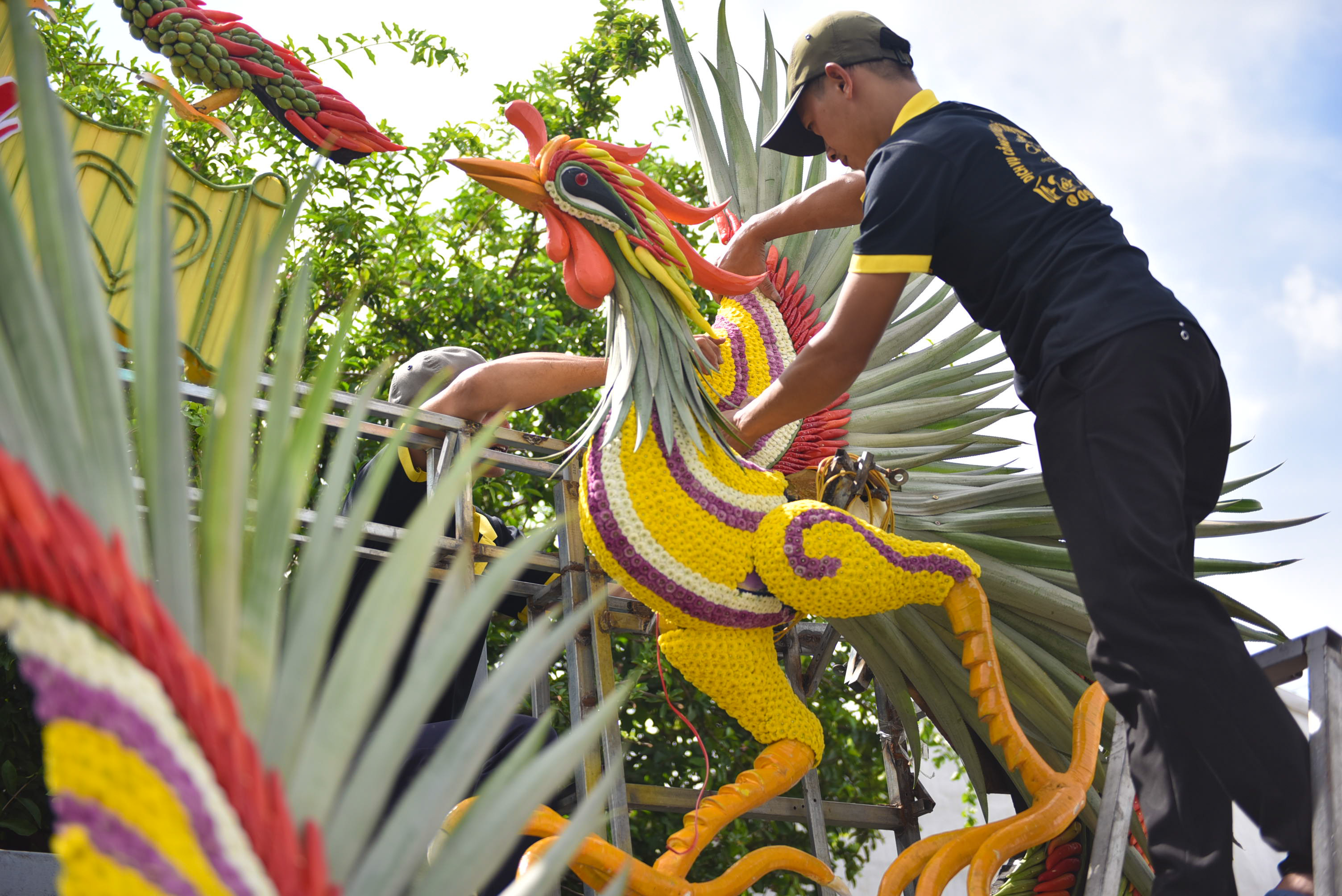 A worker attaches a phoenix on a wedding gate in District 12, Ho Chi Minh City. Photo: Ngọc Phượng / Tuoi Tre News